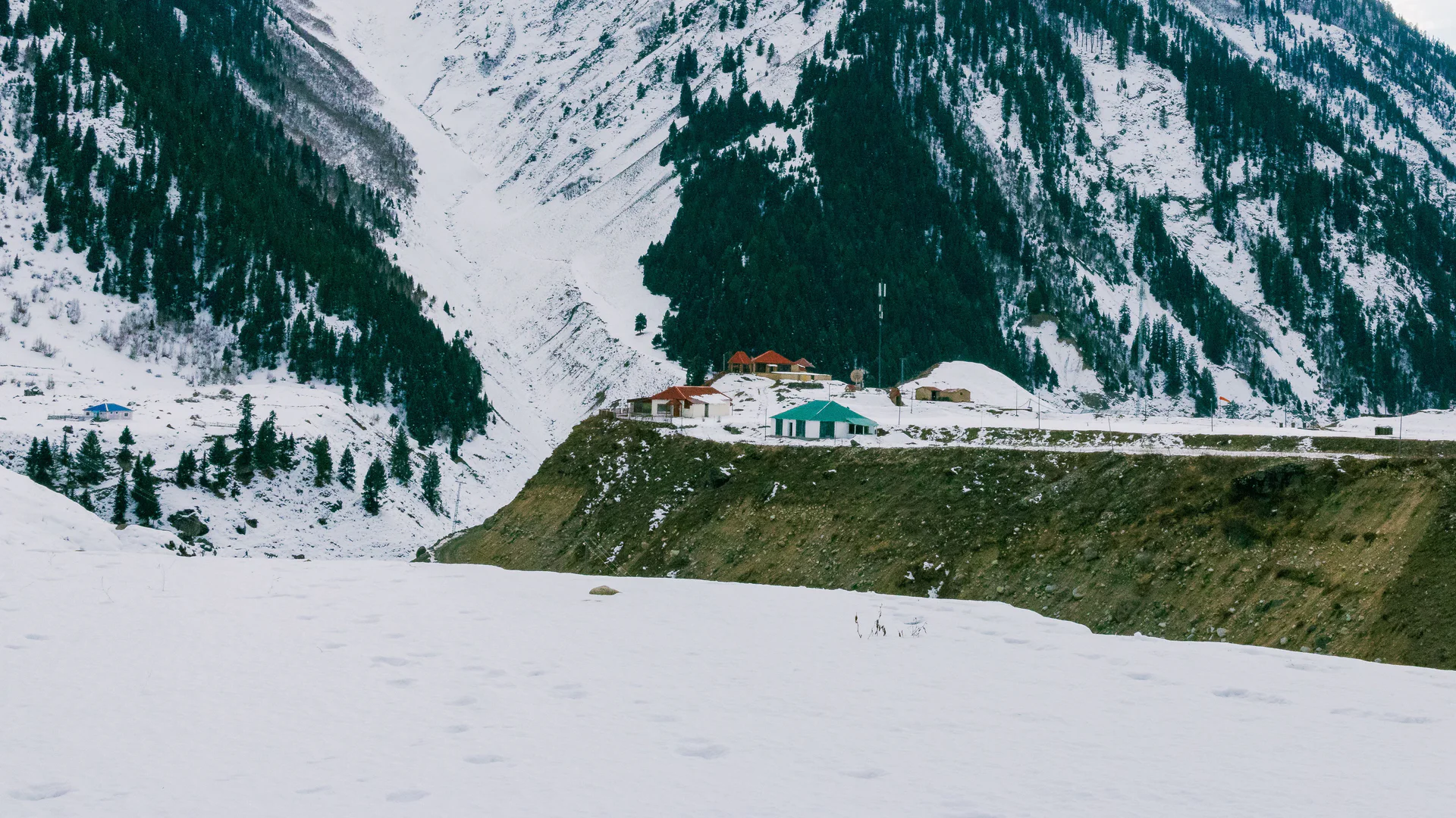 A snow-covered mountain valley and cabin in Minimarg, Astore