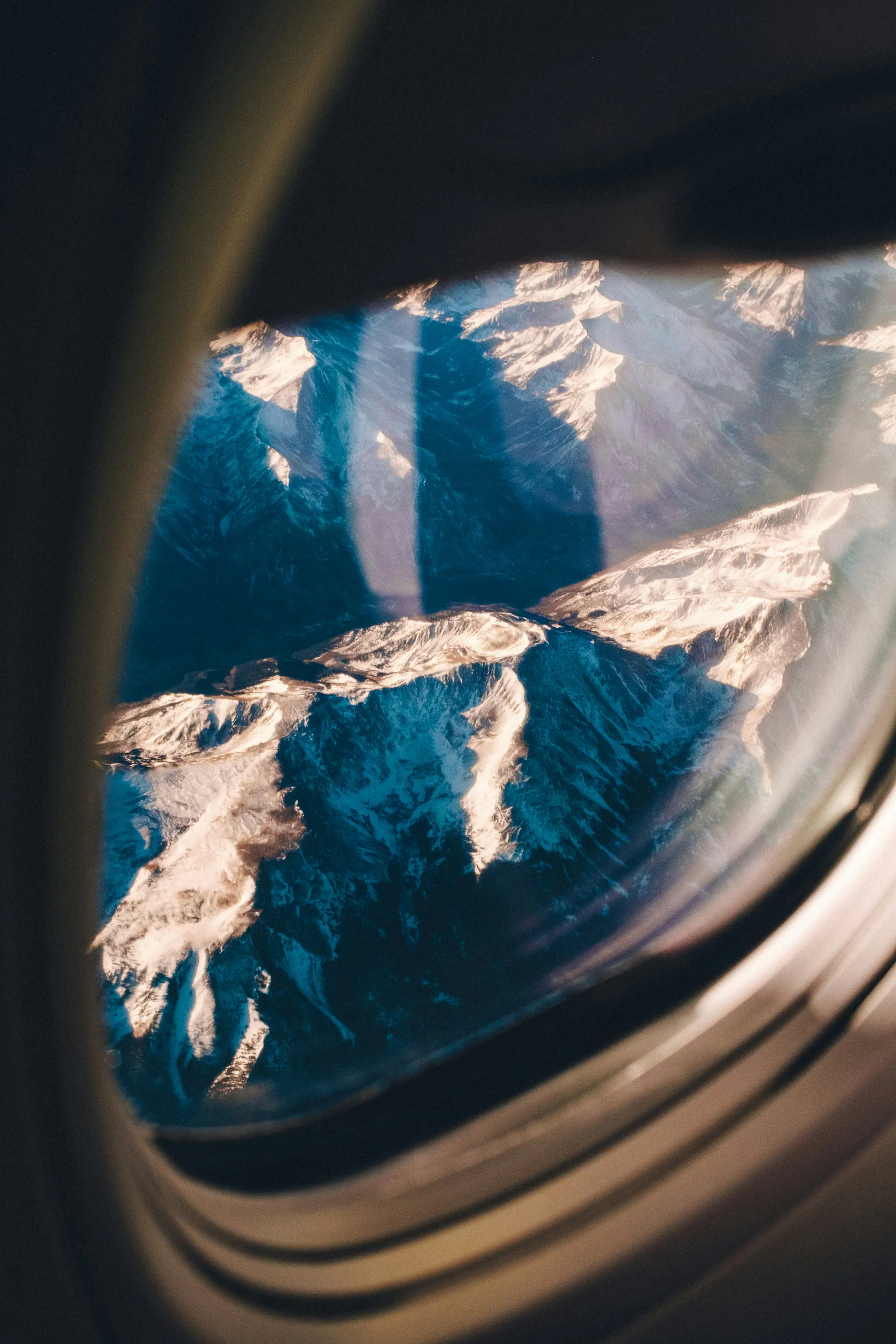 Snow-covered mountains seen through an airplane window