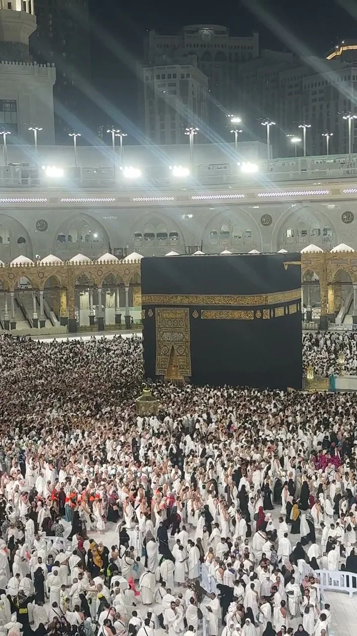 The Kaaba and pilgrims illuminated at night inside Masjid al-Haram